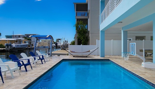 Sprawling waterfront home with pool, outdoor kitchen, game table, grill, & W/D